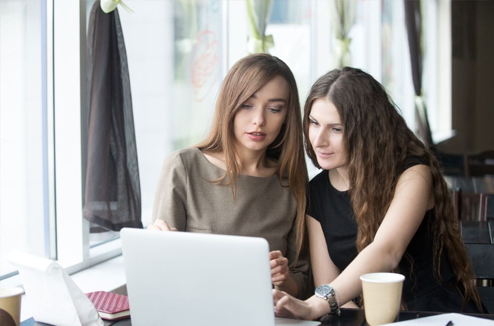 two women looking at a laptop screen